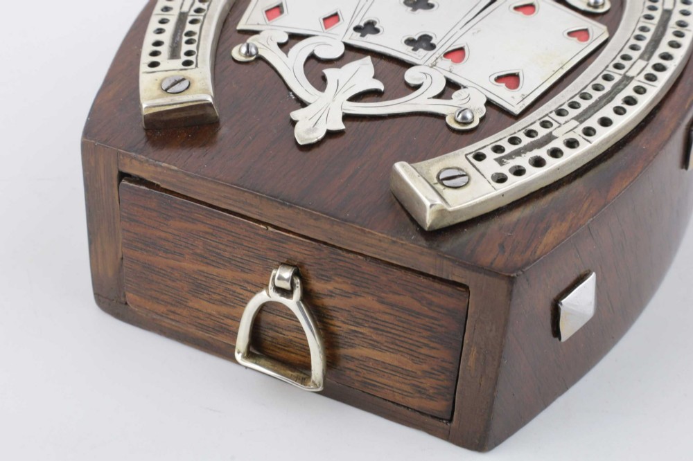 An antique horseshoe-shaped dark oak games box featuring silver metal scrollwork, playing card motifs, and an integrated cribbage scoring track. View VI