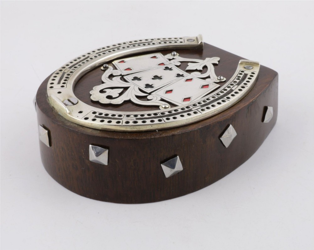 An antique horseshoe-shaped dark oak games box featuring silver metal scrollwork, playing card motifs, and an integrated cribbage scoring track. View VII