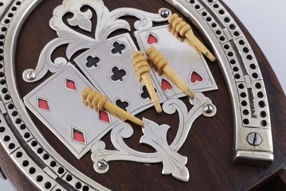 An antique horseshoe-shaped dark oak games box featuring silver metal scrollwork, playing card motifs, and an integrated cribbage scoring track. View IX