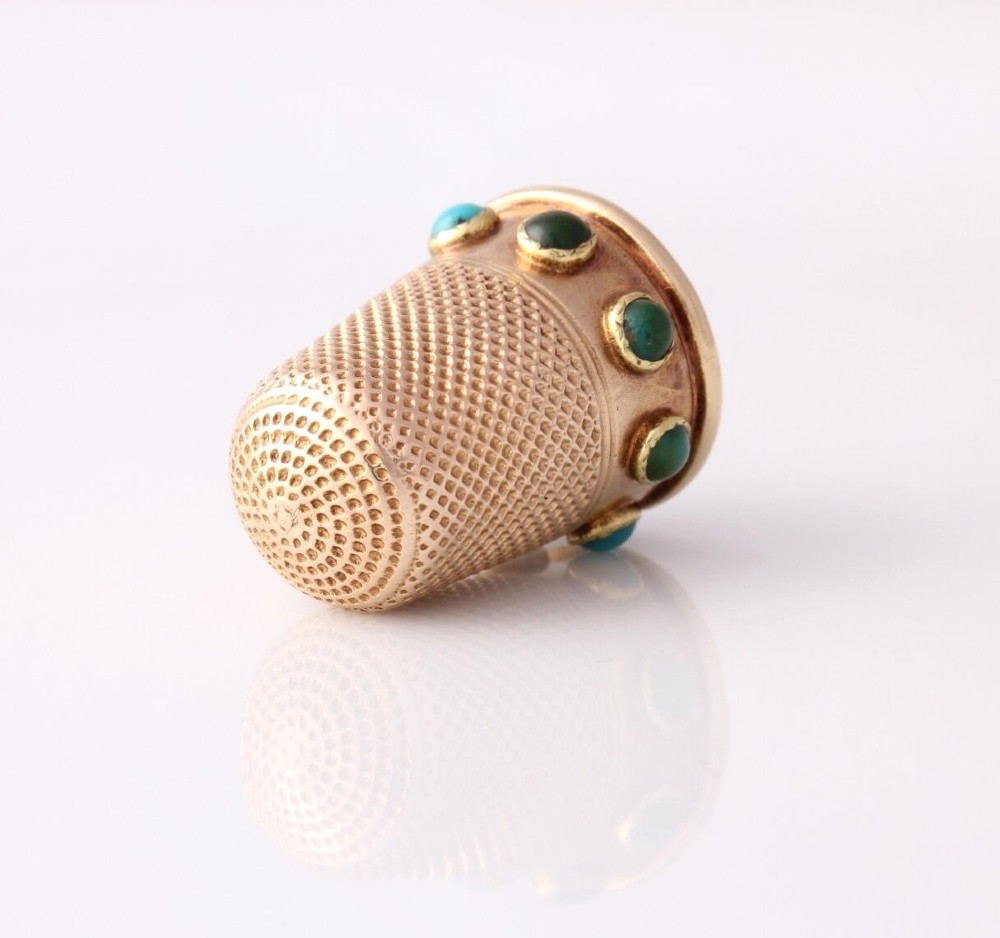 An antique Victorian 15ct gold thimble with turquoise cabochon studs displayed inside an open red leather velvet-lined case. View III