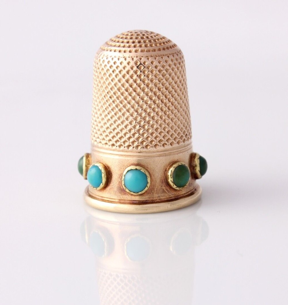 An antique Victorian 15ct gold thimble with turquoise cabochon studs displayed inside an open red leather velvet-lined case. View V