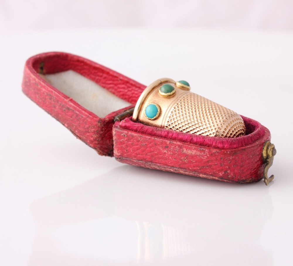 An antique Victorian 15ct gold thimble with turquoise cabochon studs displayed inside an open red leather velvet-lined case. View VI