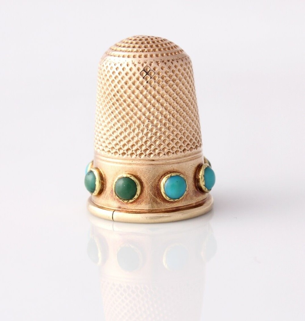 An antique Victorian 15ct gold thimble with turquoise cabochon studs displayed inside an open red leather velvet-lined case. View VII