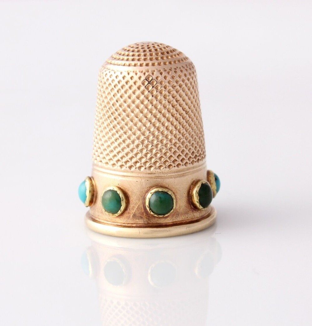 An antique Victorian 15ct gold thimble with turquoise cabochon studs displayed inside an open red leather velvet-lined case. View VIII