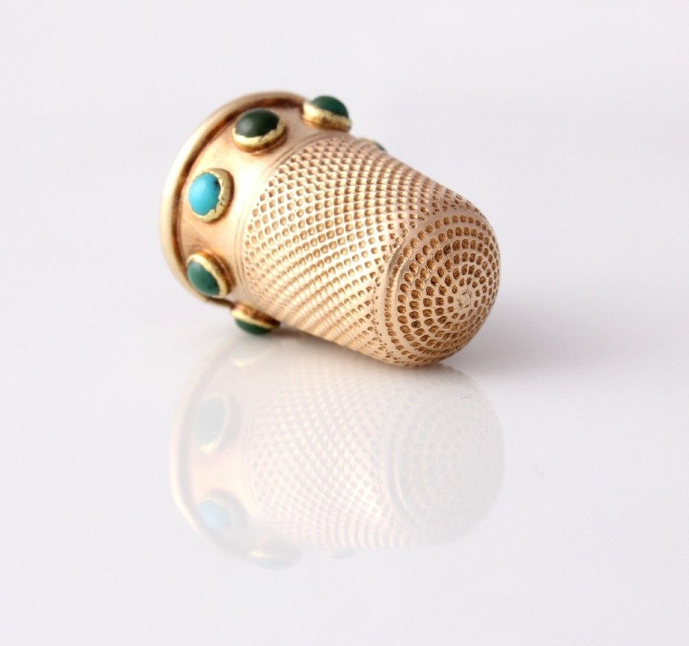 An antique Victorian 15ct gold thimble with turquoise cabochon studs displayed inside an open red leather velvet-lined case. View IX