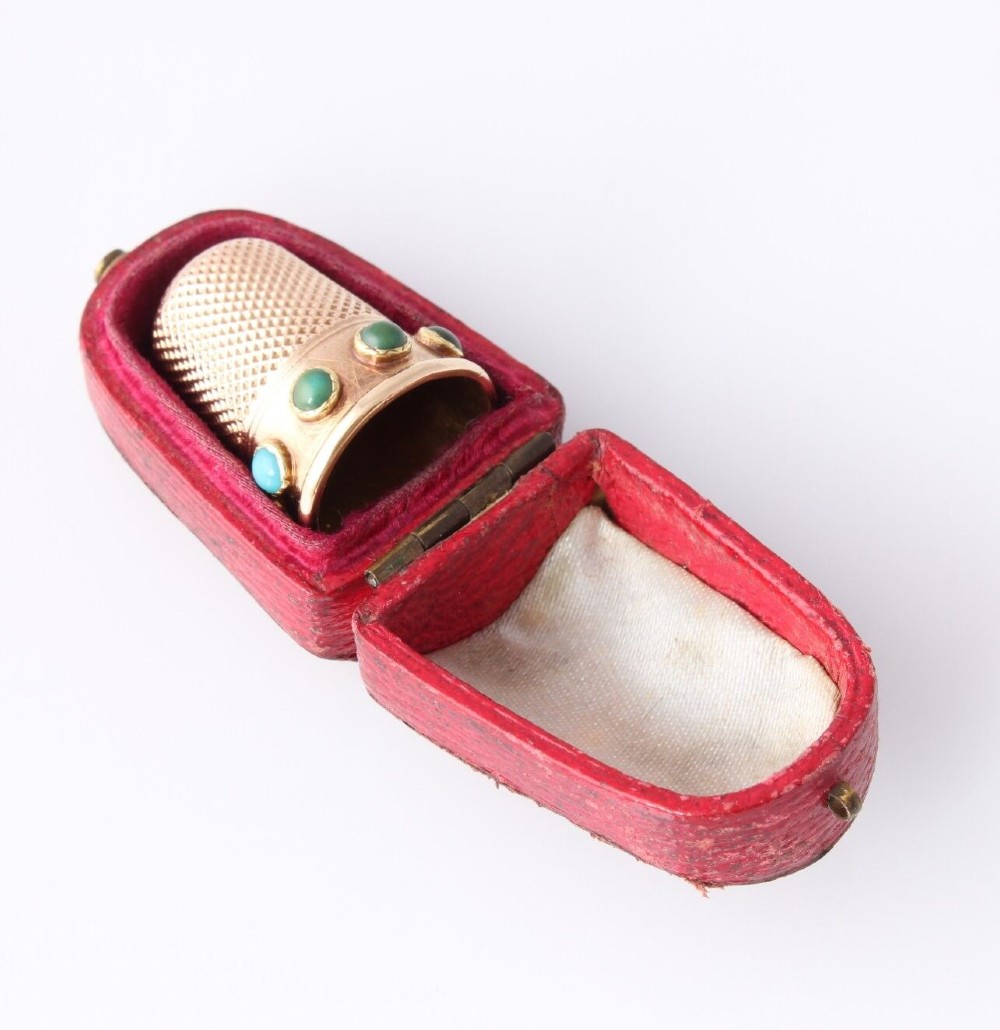 An antique Victorian 15ct gold thimble with turquoise cabochon studs displayed inside an open red leather velvet-lined case. View XI