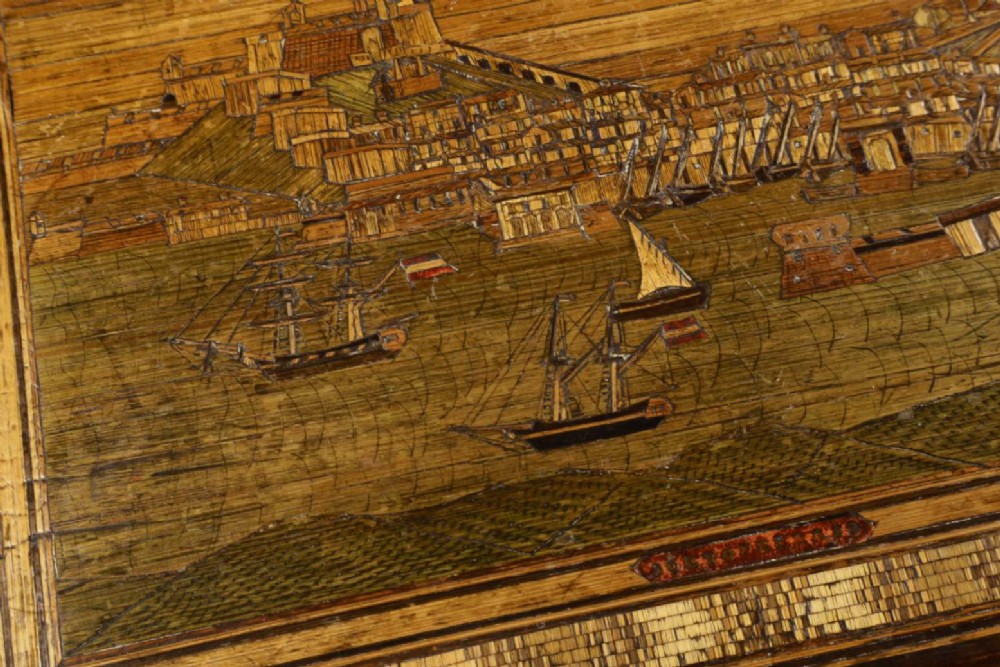 A rectangular wooden box top featuring intricate straw marquetry depicting a harbour landscape with ships, fortresses, and geometric borders. View IV