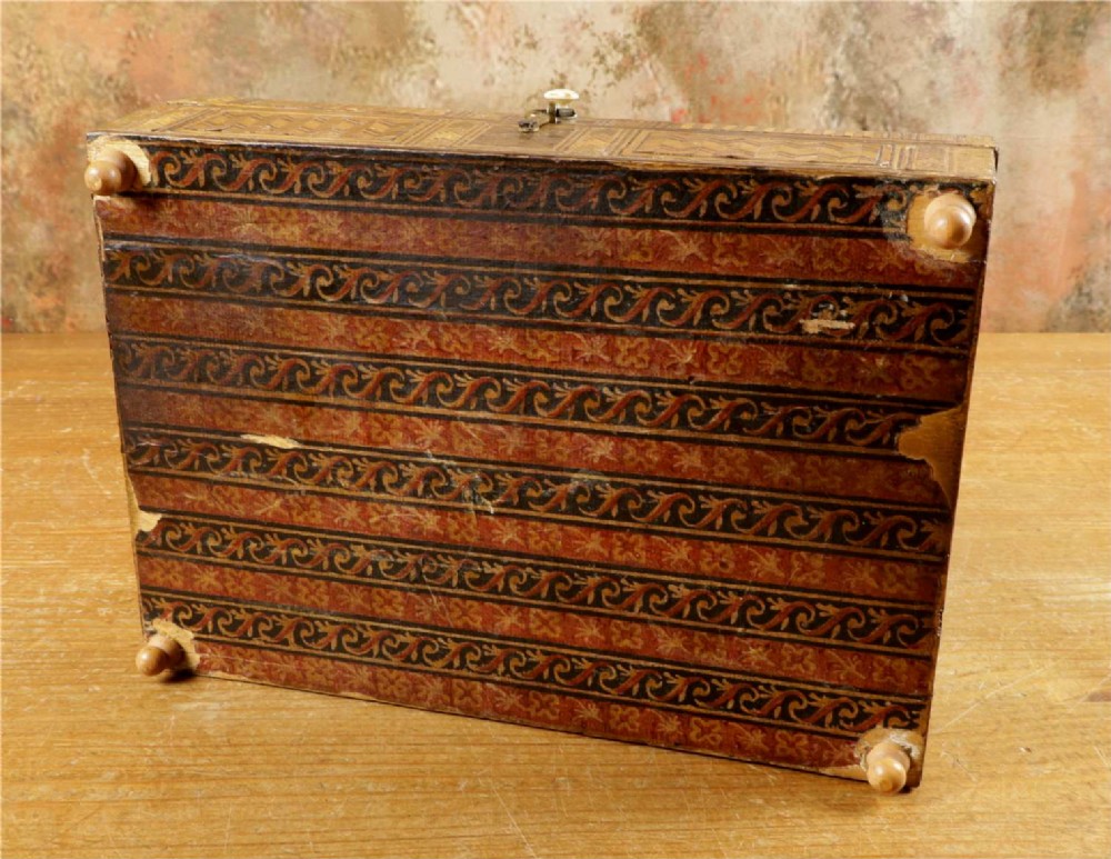A rectangular wooden box top featuring intricate straw marquetry depicting a harbour landscape with ships, fortresses, and geometric borders. View XV