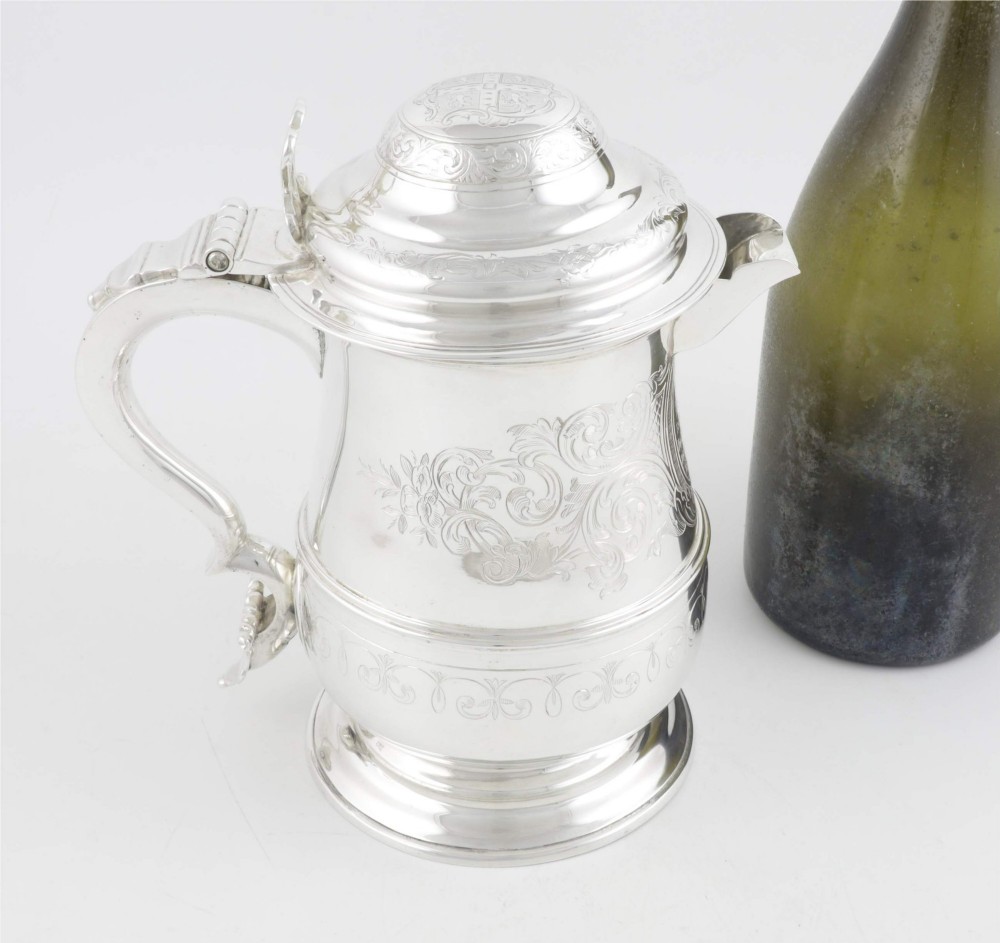 An engraved silver lidded jug featuring a hinged cap, scrolling handle, and foliate engraving across the body. View IV
