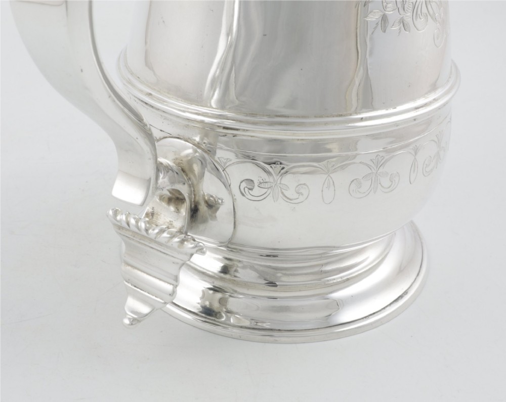 An engraved silver lidded jug featuring a hinged cap, scrolling handle, and foliate engraving across the body. View XIII