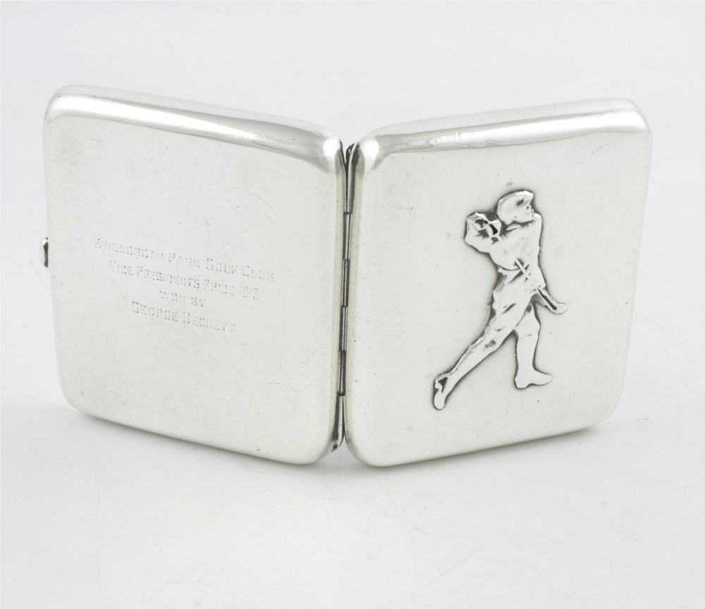 An Edwardian sterling silver cigarette case featuring an embossed relief figure of a golfer in mid-swing on the front cover. View IV