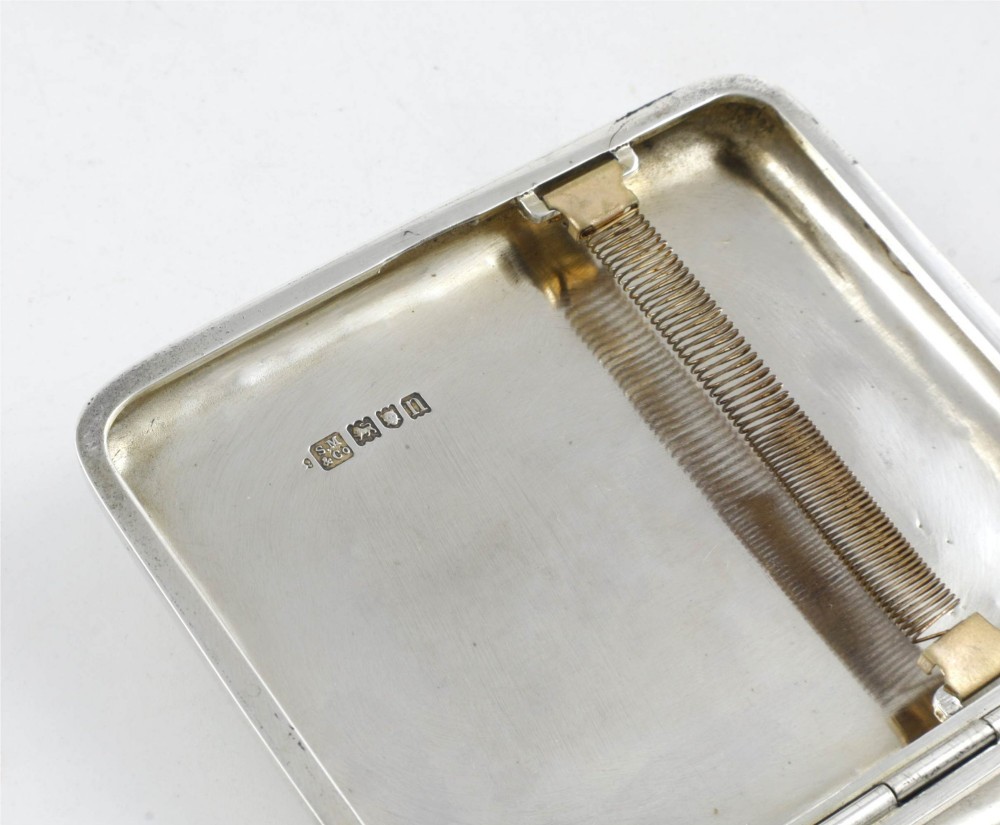 An Edwardian sterling silver cigarette case featuring an embossed relief figure of a golfer in mid-swing on the front cover. View X