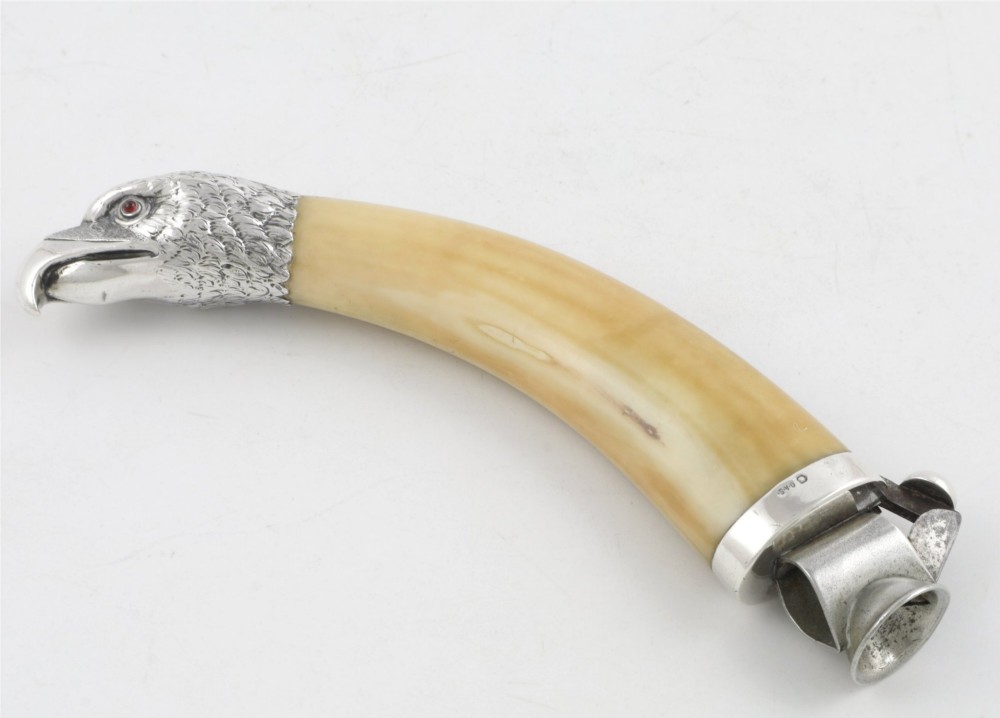 An antique cigar cutter crafted from a curved cream-coloured boar tusk fitted with a cast silver eagle head terminal and a silver cutting mechanism at the opposing end. View III