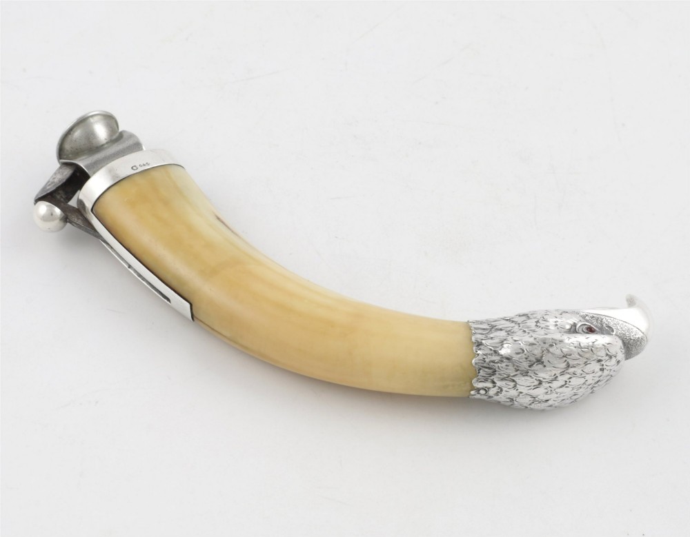 An antique cigar cutter crafted from a curved cream-coloured boar tusk fitted with a cast silver eagle head terminal and a silver cutting mechanism at the opposing end. View IV