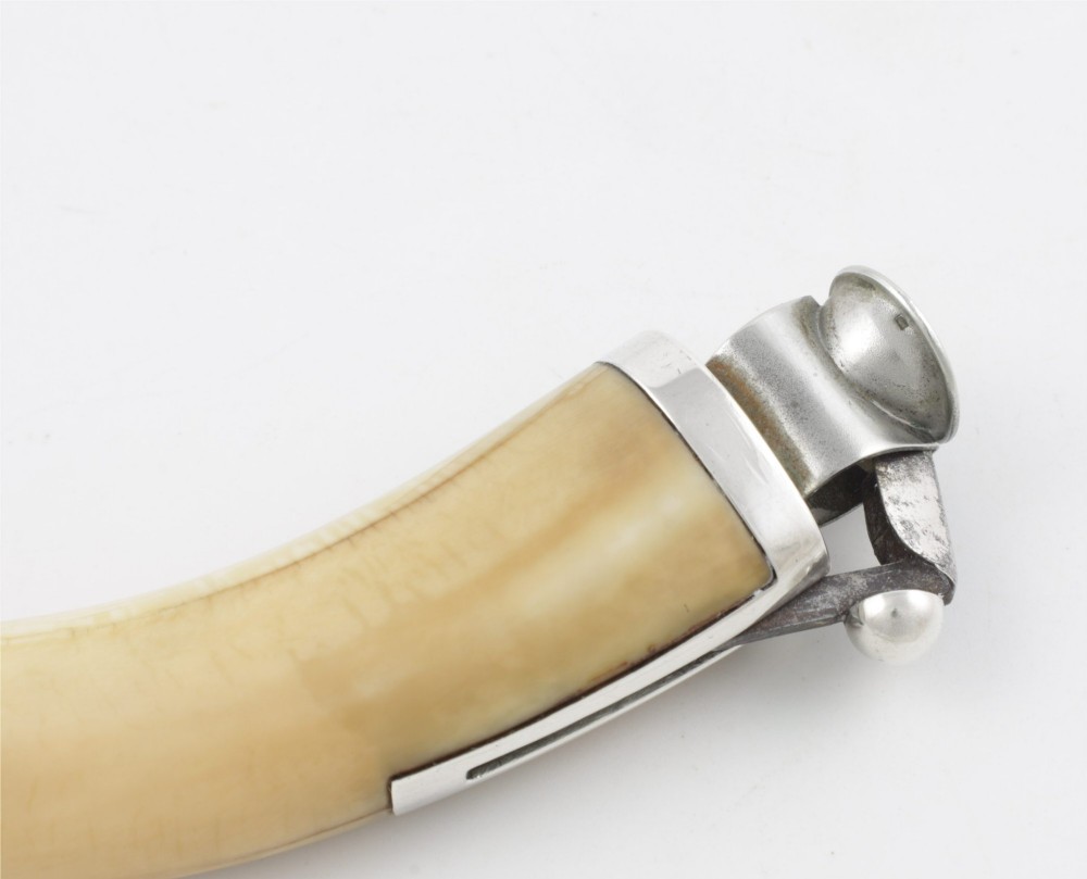 An antique cigar cutter crafted from a curved cream-coloured boar tusk fitted with a cast silver eagle head terminal and a silver cutting mechanism at the opposing end. View VII