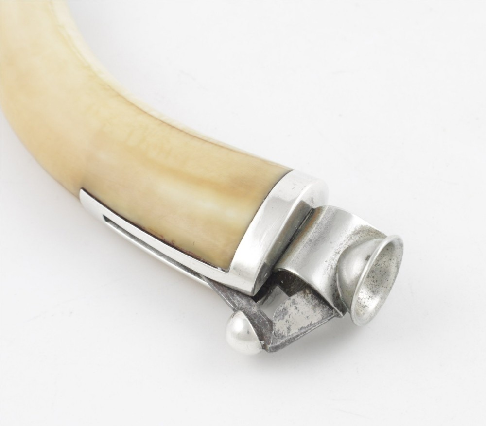 An antique cigar cutter crafted from a curved cream-coloured boar tusk fitted with a cast silver eagle head terminal and a silver cutting mechanism at the opposing end. View XI