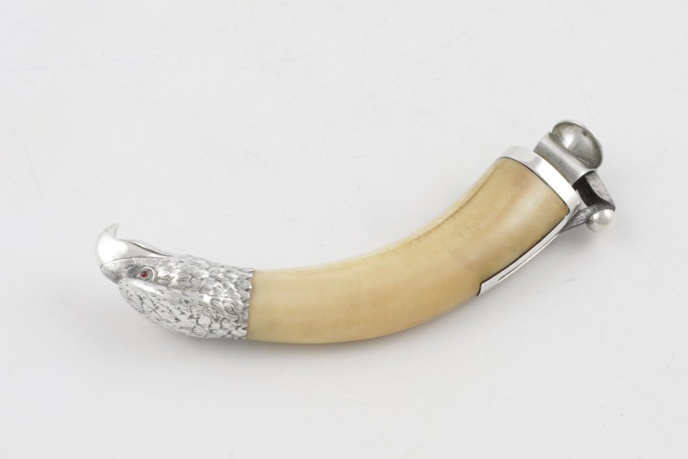 An antique cigar cutter crafted from a curved cream-coloured boar tusk fitted with a cast silver eagle head terminal and a silver cutting mechanism at the opposing end. View XIII