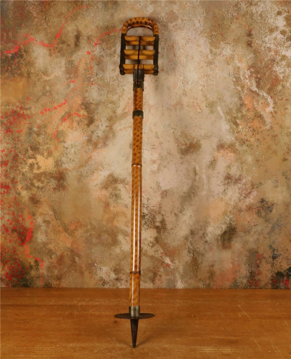 A late 19th-century bamboo shooting stick featuring a folding seat handle, metal support struts, and a spiked metal base. View VI