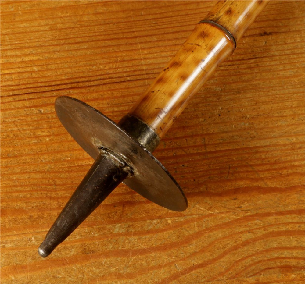 A late 19th-century bamboo shooting stick featuring a folding seat handle, metal support struts, and a spiked metal base. View XII