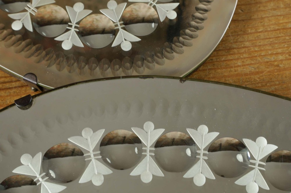 A pair of oval glass sorcerer mirrors featuring central dark reflections surrounded by a border of etched botanical motifs and raised convex glass lenses. View VIII