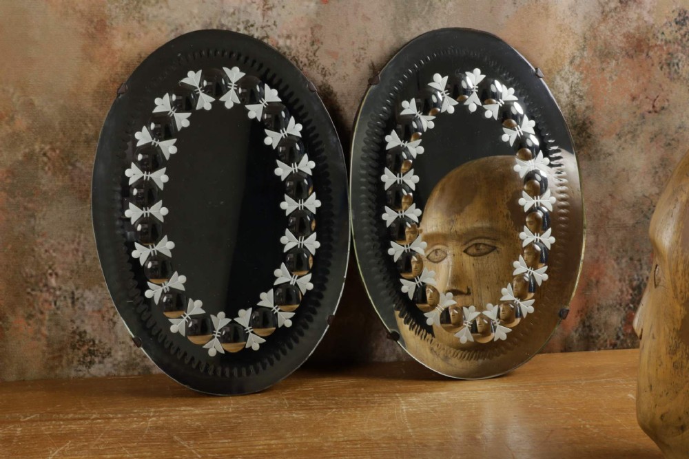A pair of oval glass sorcerer mirrors featuring central dark reflections surrounded by a border of etched botanical motifs and raised convex glass lenses. View XIV