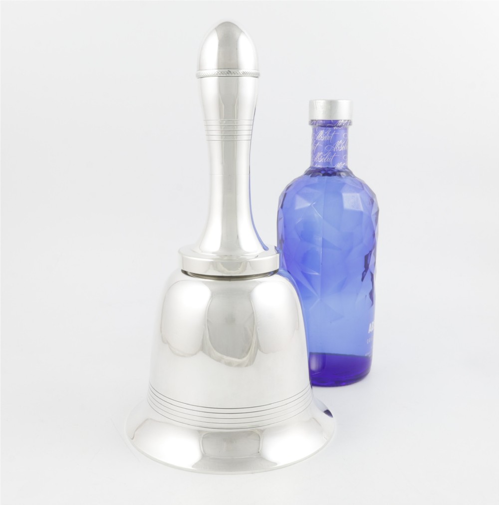A silver plated novelty cocktail shaker in the shape of a handbell with a smooth turned handle and incised line detailing. View II
