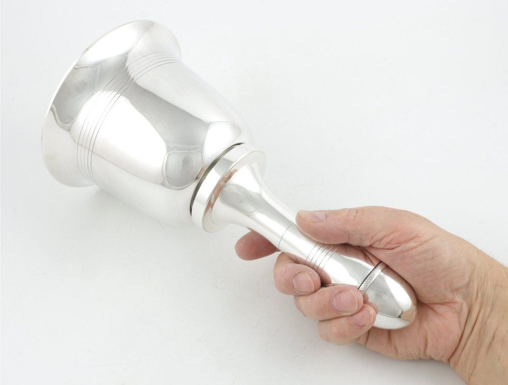 A silver plated novelty cocktail shaker in the shape of a handbell with a smooth turned handle and incised line detailing. View VII