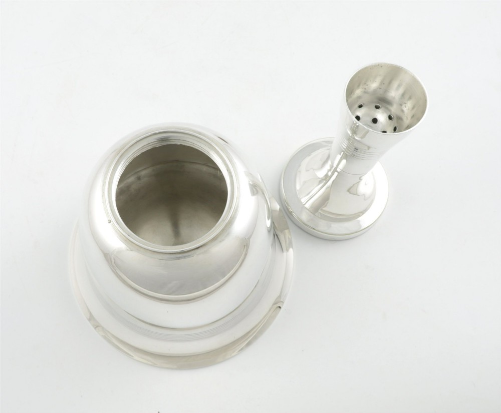 A silver plated novelty cocktail shaker in the shape of a handbell with a smooth turned handle and incised line detailing. View XIII