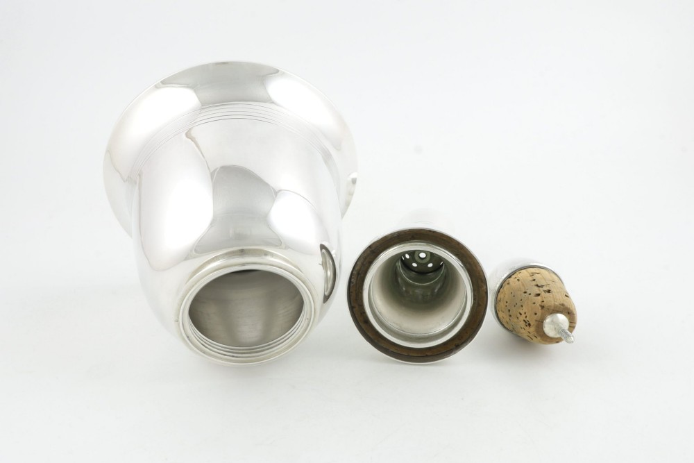 A silver plated novelty cocktail shaker in the shape of a handbell with a smooth turned handle and incised line detailing. View XIV