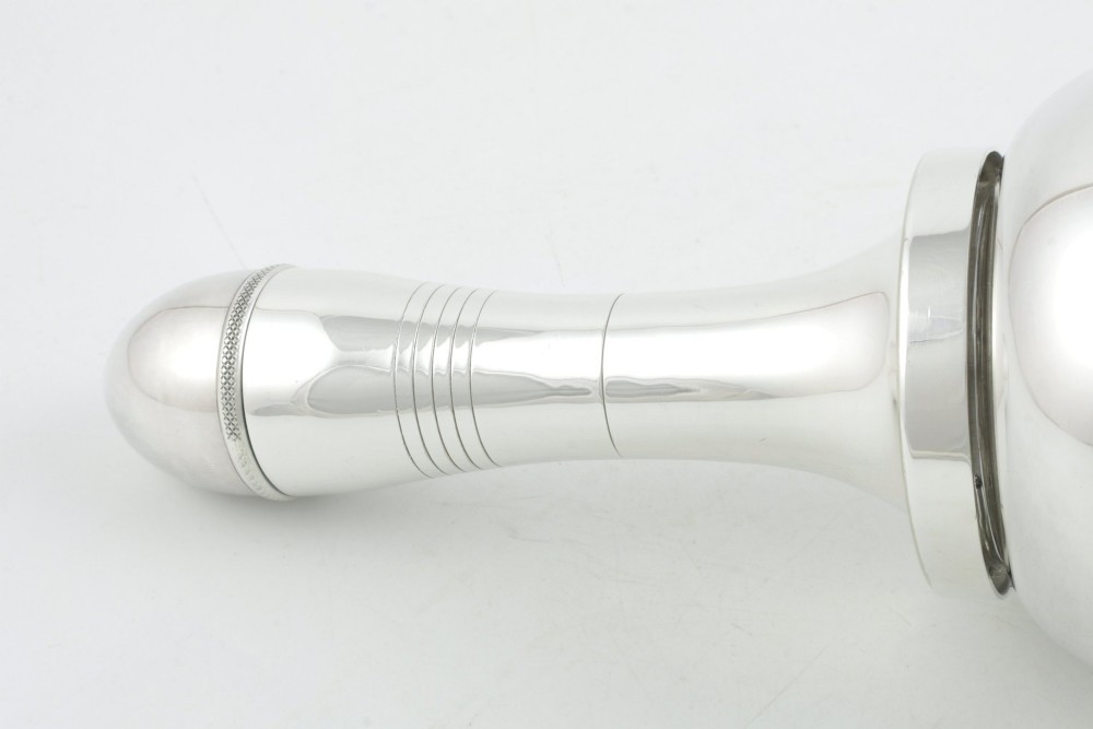 A silver plated novelty cocktail shaker in the shape of a handbell with a smooth turned handle and incised line detailing. View XV