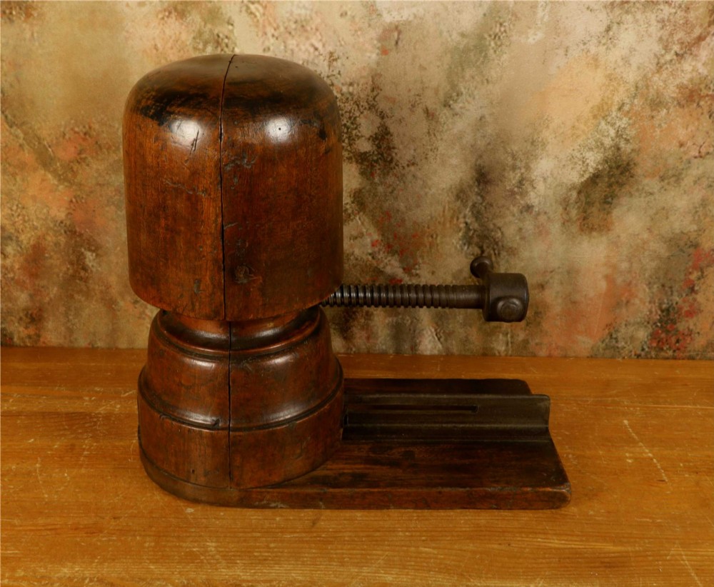 An antique French milliners hat stretcher crafted from dark polished wood with a split head block and an adjustable iron turn-screw mechanism set on a flat timber base. View IV