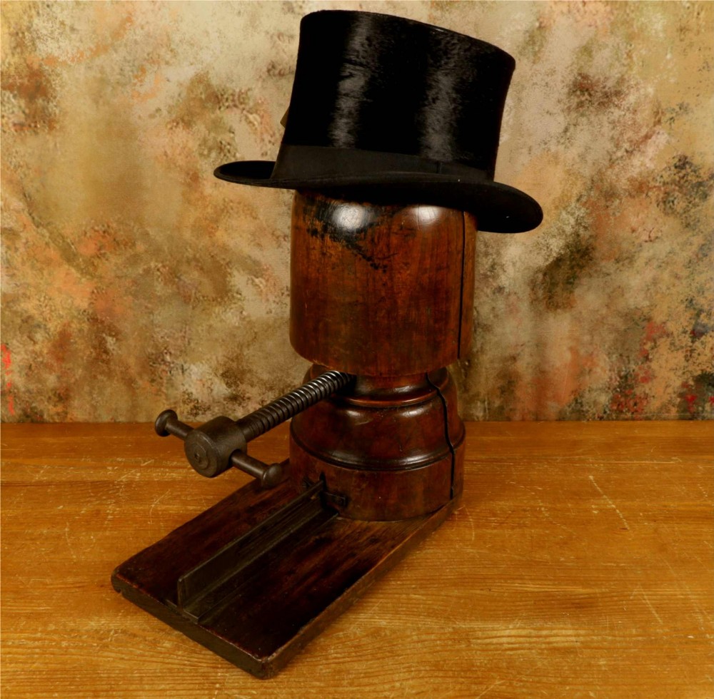 An antique French milliners hat stretcher crafted from dark polished wood with a split head block and an adjustable iron turn-screw mechanism set on a flat timber base. View V