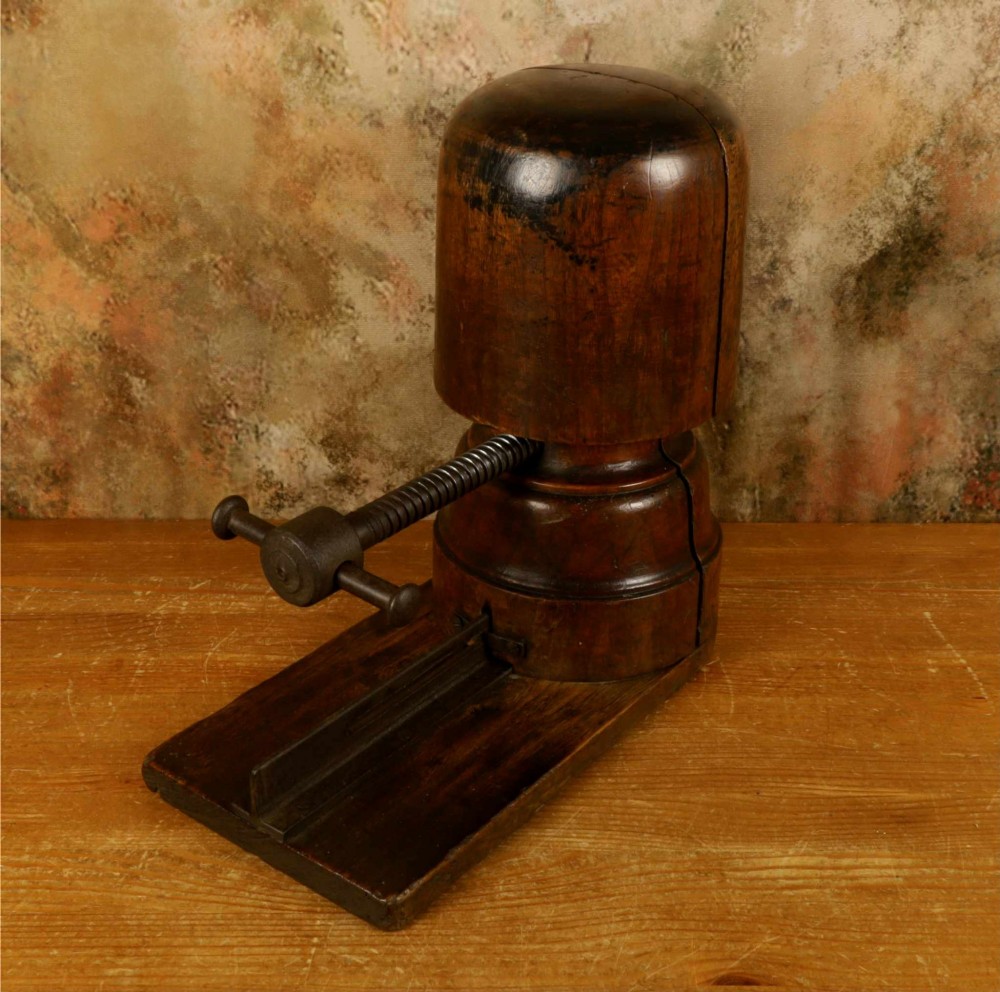 An antique French milliners hat stretcher crafted from dark polished wood with a split head block and an adjustable iron turn-screw mechanism set on a flat timber base. View VI