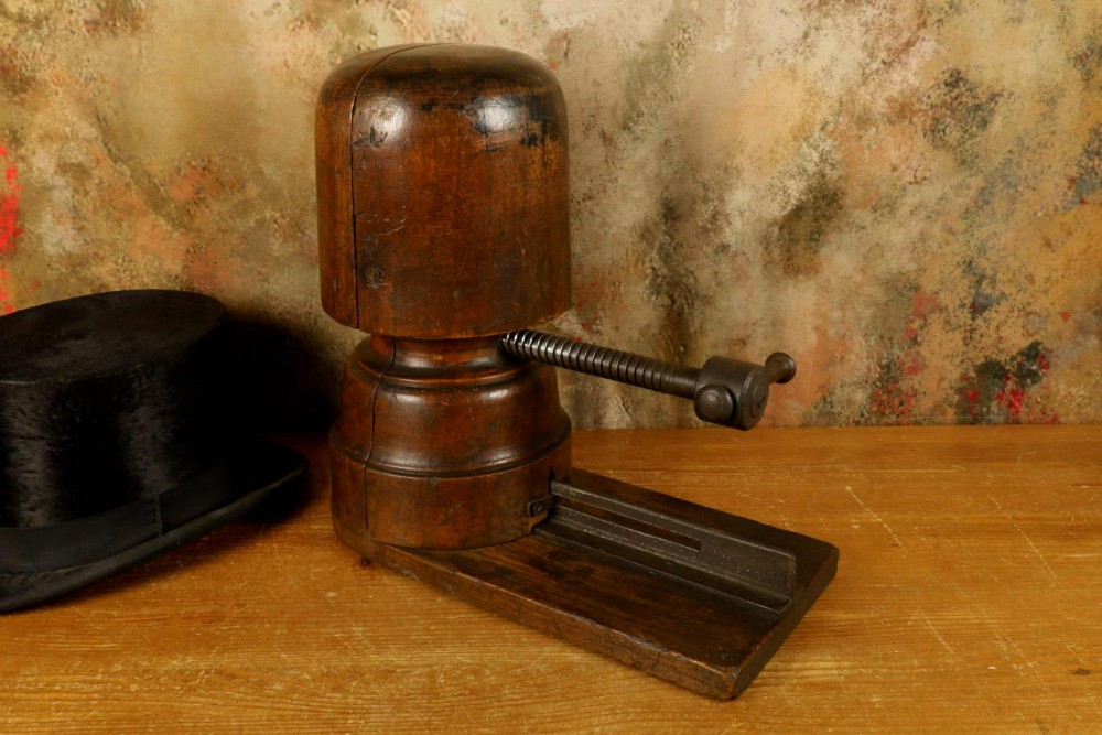 An antique French milliners hat stretcher crafted from dark polished wood with a split head block and an adjustable iron turn-screw mechanism set on a flat timber base. View XI