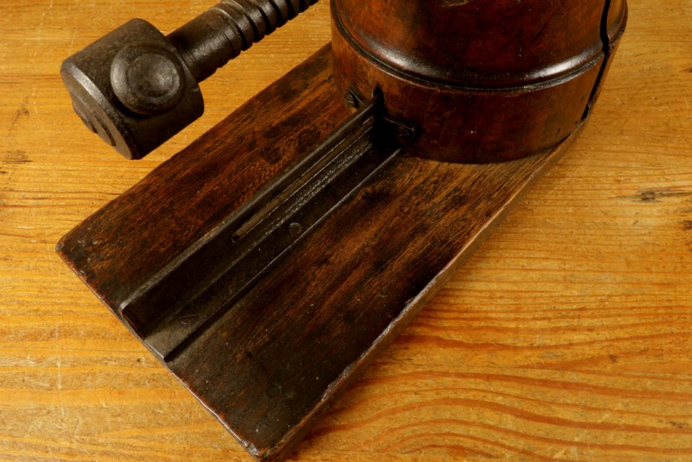 An antique French milliners hat stretcher crafted from dark polished wood with a split head block and an adjustable iron turn-screw mechanism set on a flat timber base. View XIII