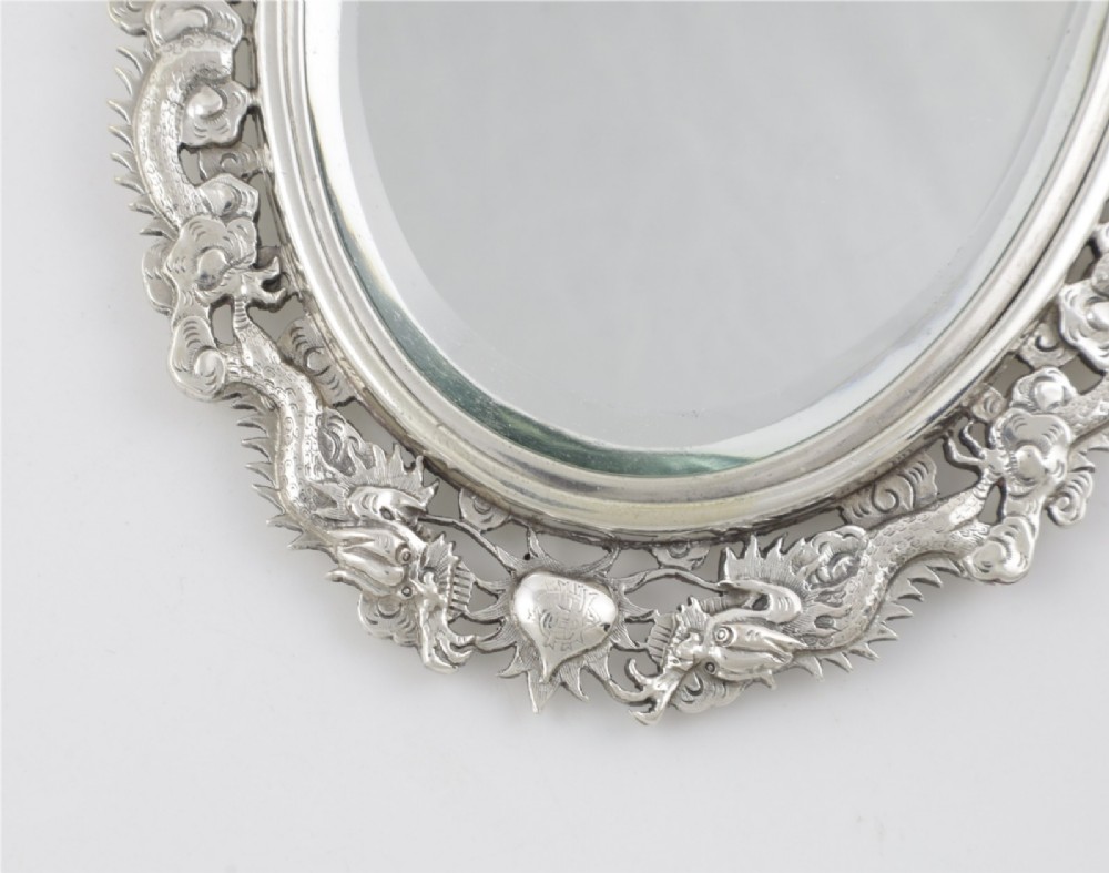 An antique silver hand mirror featuring a dragon motif frame and an interconnected faux-bamboo handle. View XIII