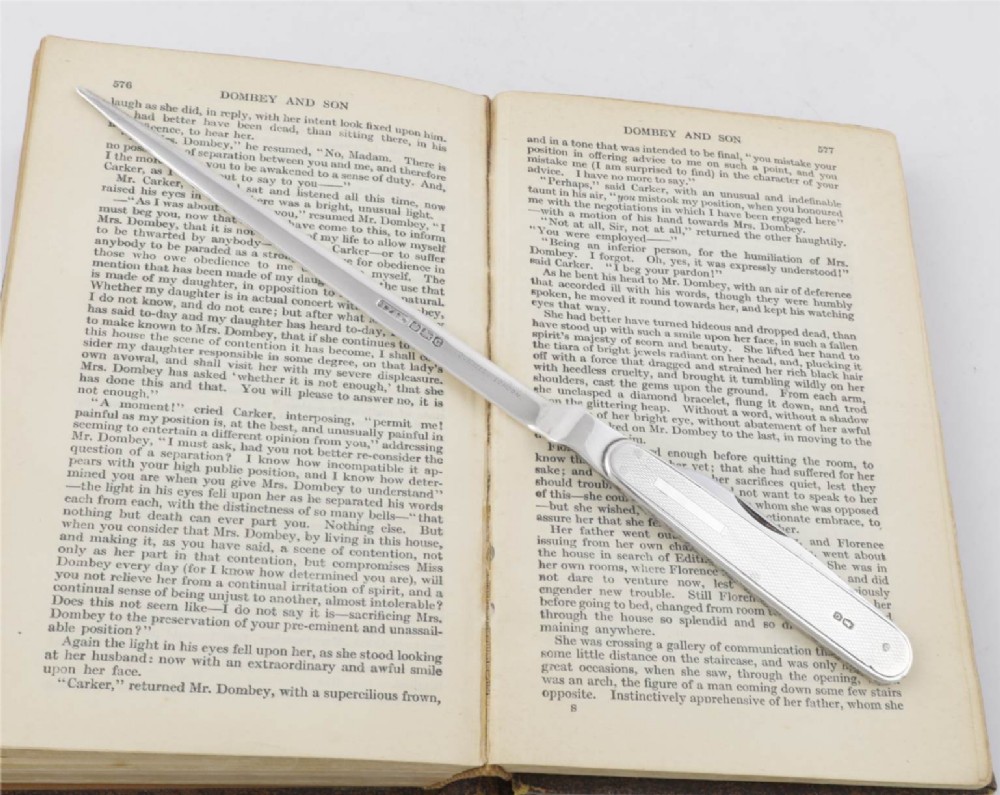 A vintage hallmarked sterling silver letter opener featuring an engine-turned handle casing with an integrated folding knife blade. View VII