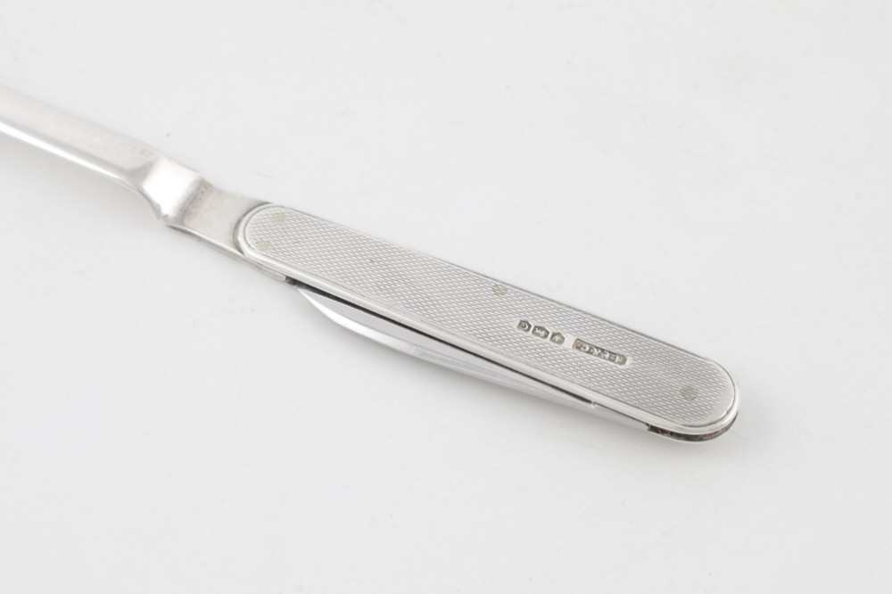 A vintage hallmarked sterling silver letter opener featuring an engine-turned handle casing with an integrated folding knife blade. View VIII