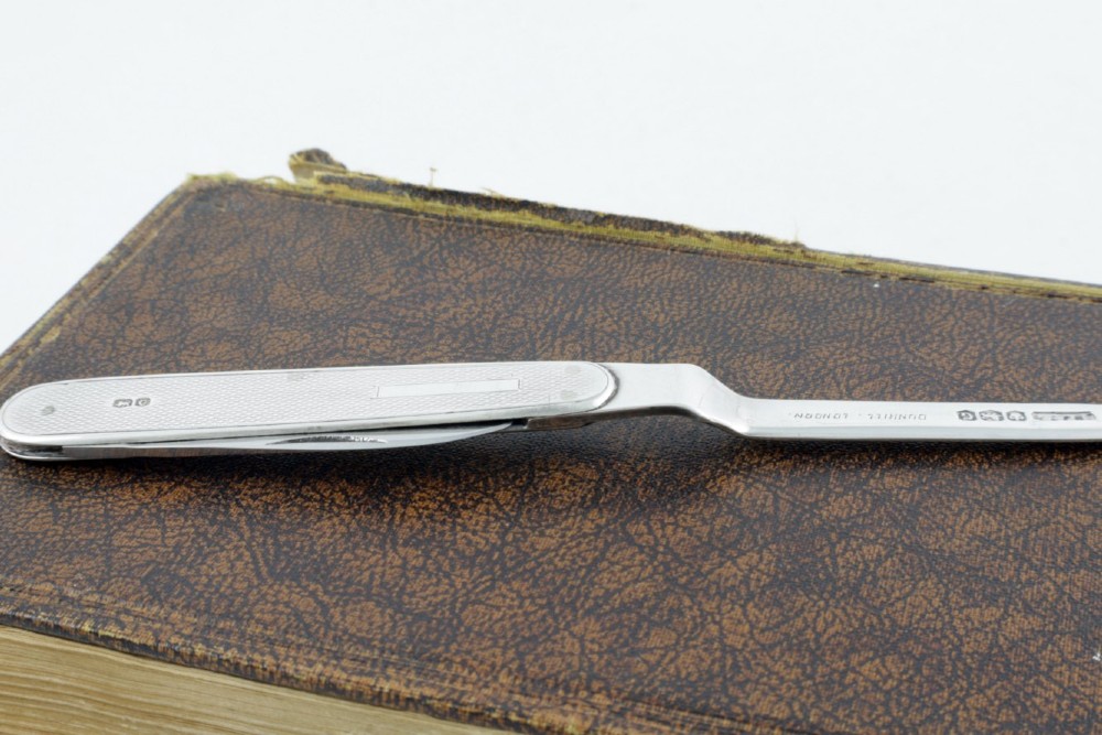 A vintage hallmarked sterling silver letter opener featuring an engine-turned handle casing with an integrated folding knife blade. View X
