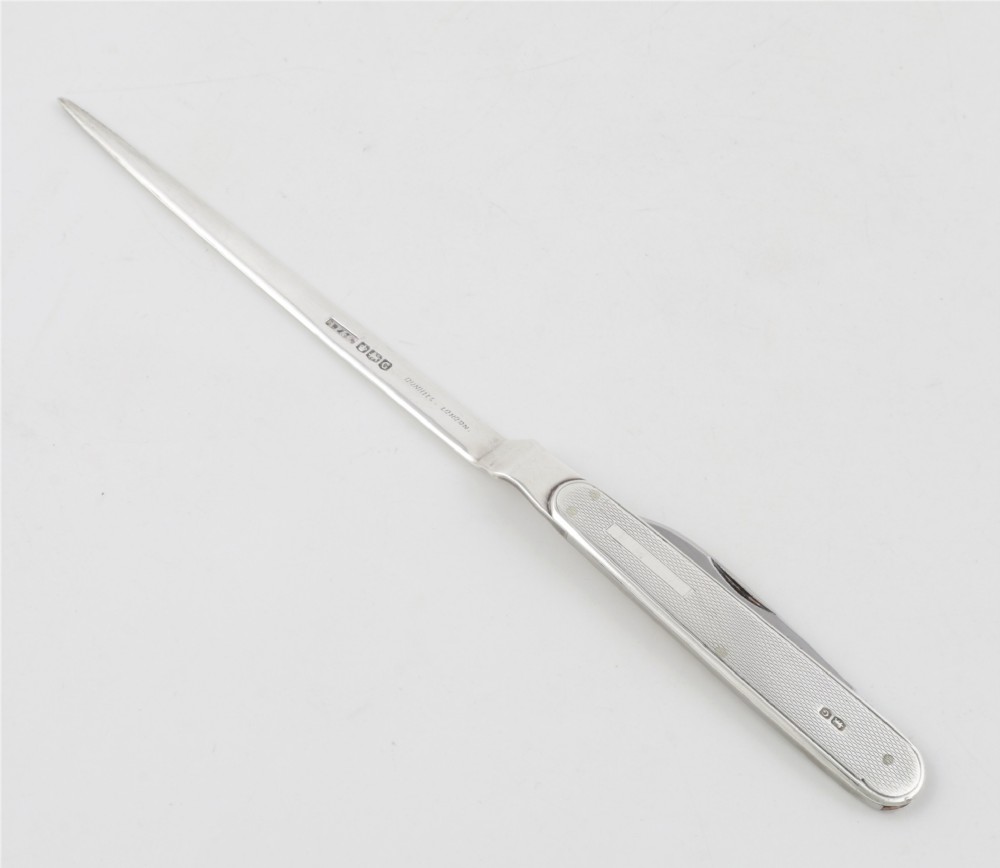 A vintage hallmarked sterling silver letter opener featuring an engine-turned handle casing with an integrated folding knife blade. View XIII