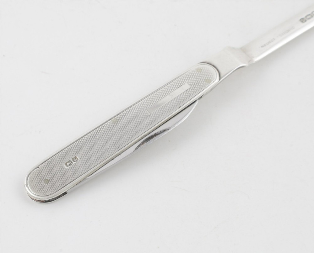 A vintage hallmarked sterling silver letter opener featuring an engine-turned handle casing with an integrated folding knife blade. View XIV