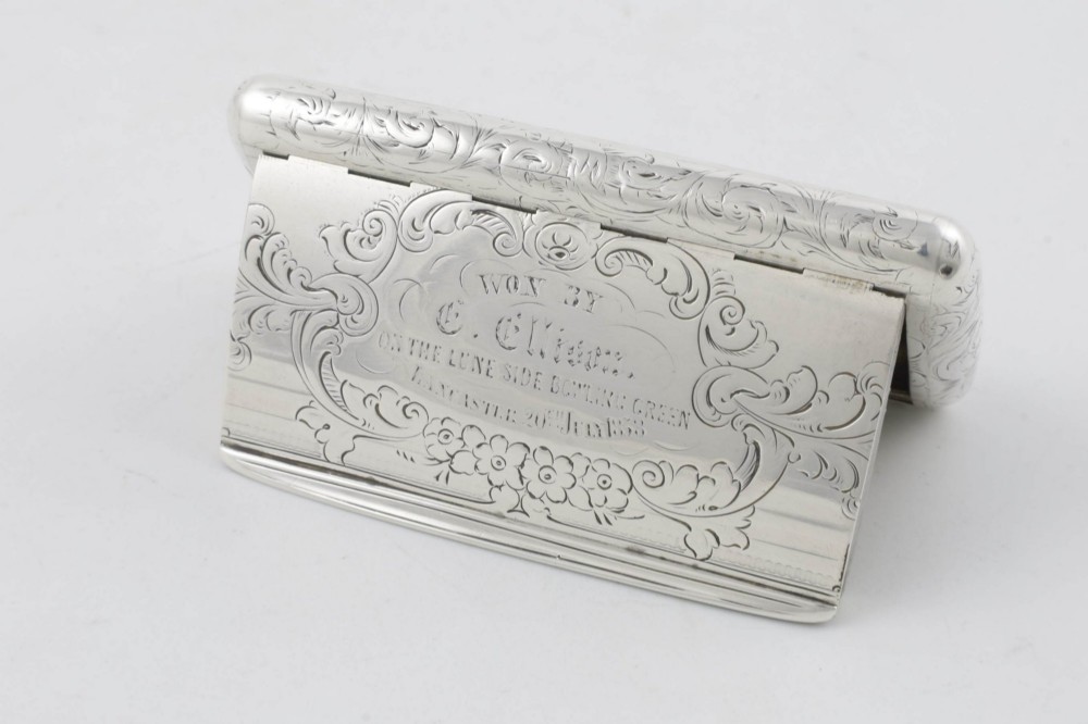 An engraved Victorian sterling silver rectangular snuff box featuring intricate foliate scrollwork and inscribed presentation text.