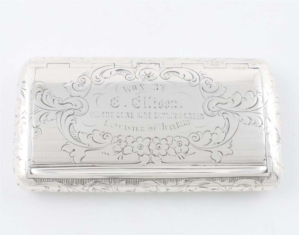An engraved Victorian sterling silver rectangular snuff box featuring intricate foliate scrollwork and inscribed presentation text. View II