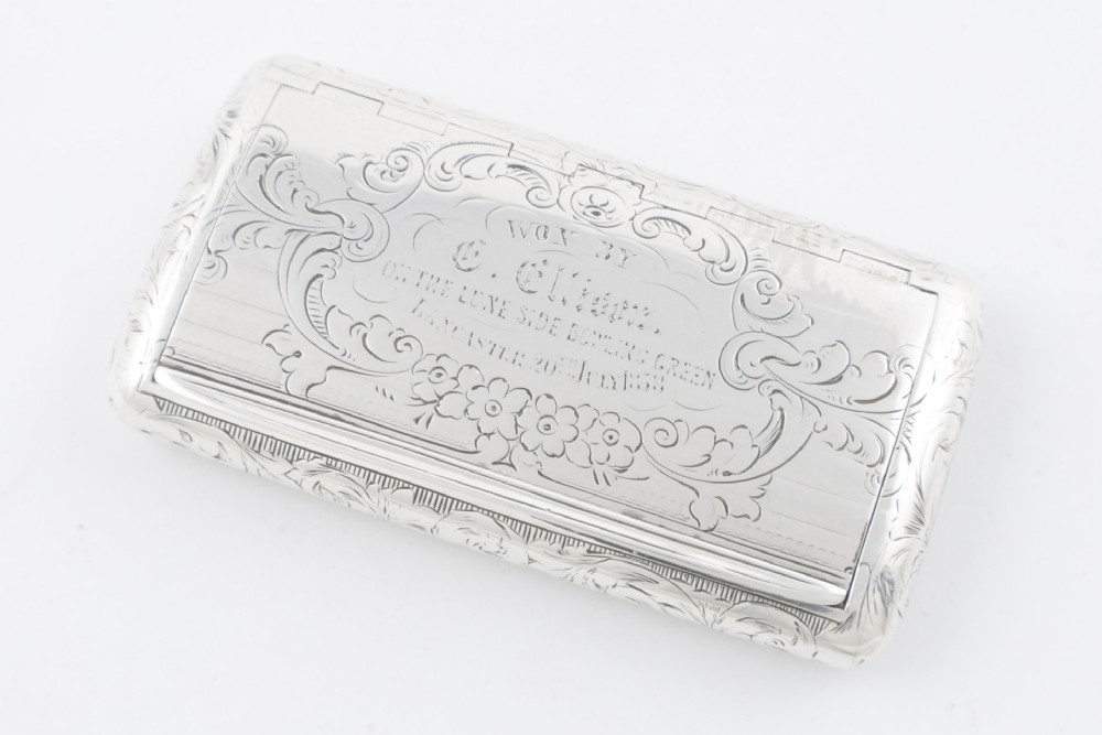 An engraved Victorian sterling silver rectangular snuff box featuring intricate foliate scrollwork and inscribed presentation text. View III