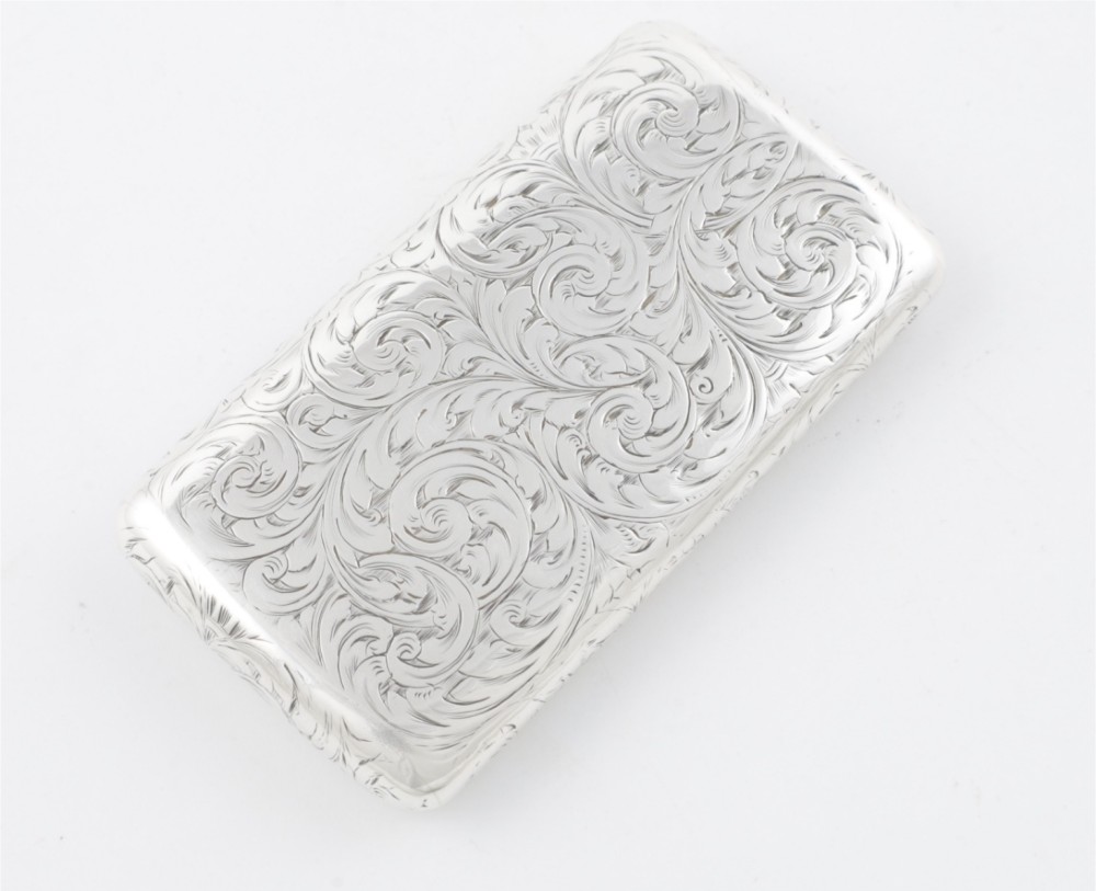 An engraved Victorian sterling silver rectangular snuff box featuring intricate foliate scrollwork and inscribed presentation text. View V