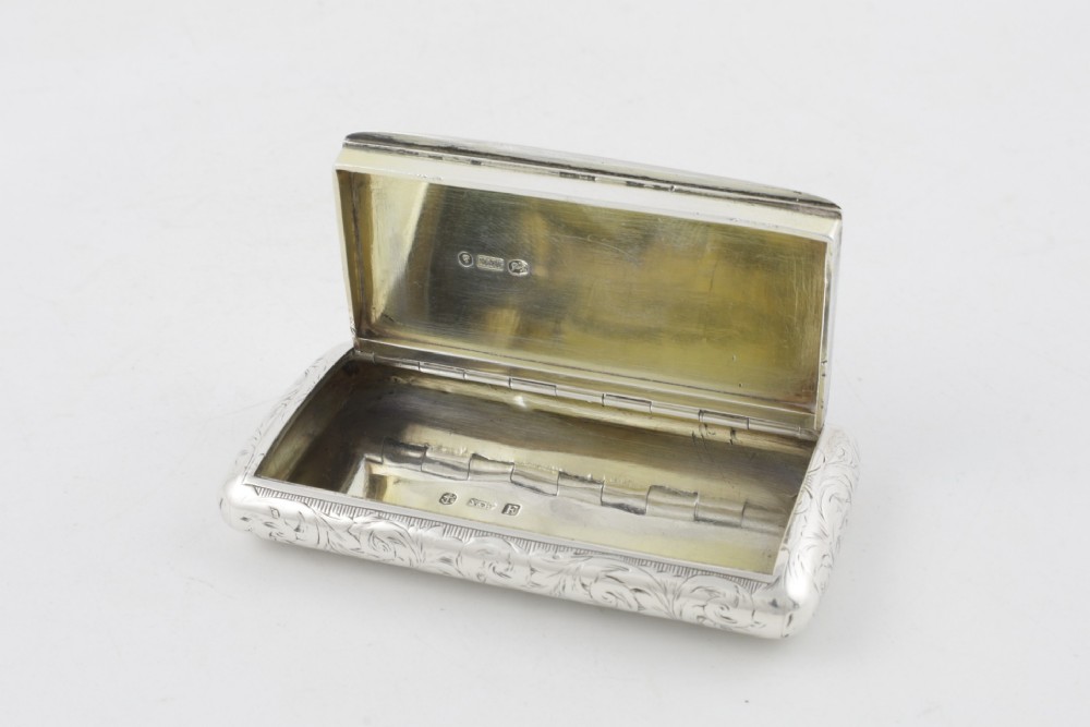 An engraved Victorian sterling silver rectangular snuff box featuring intricate foliate scrollwork and inscribed presentation text. View IX