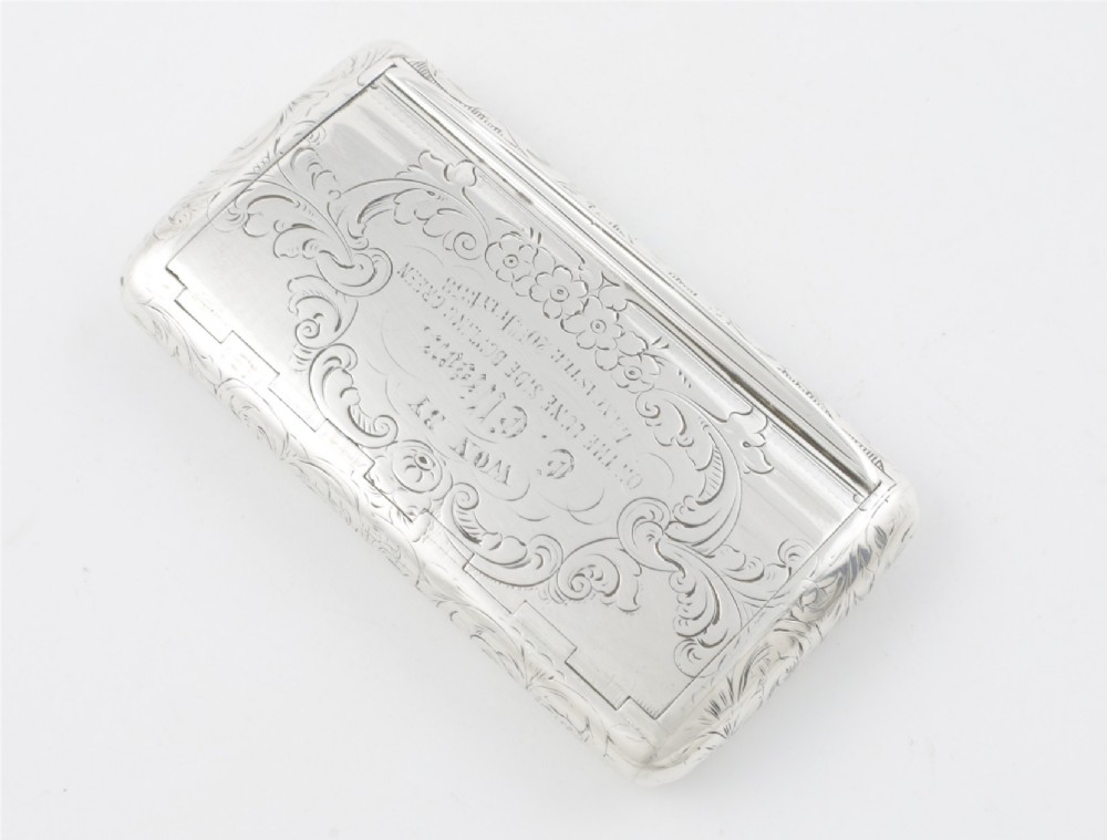 An engraved Victorian sterling silver rectangular snuff box featuring intricate foliate scrollwork and inscribed presentation text. View XI