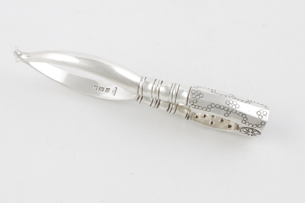 A pair of hallmarked sterling silver nutcrackers with hinged, textured jaws and curved handles featuring decorative chasing. View XIV