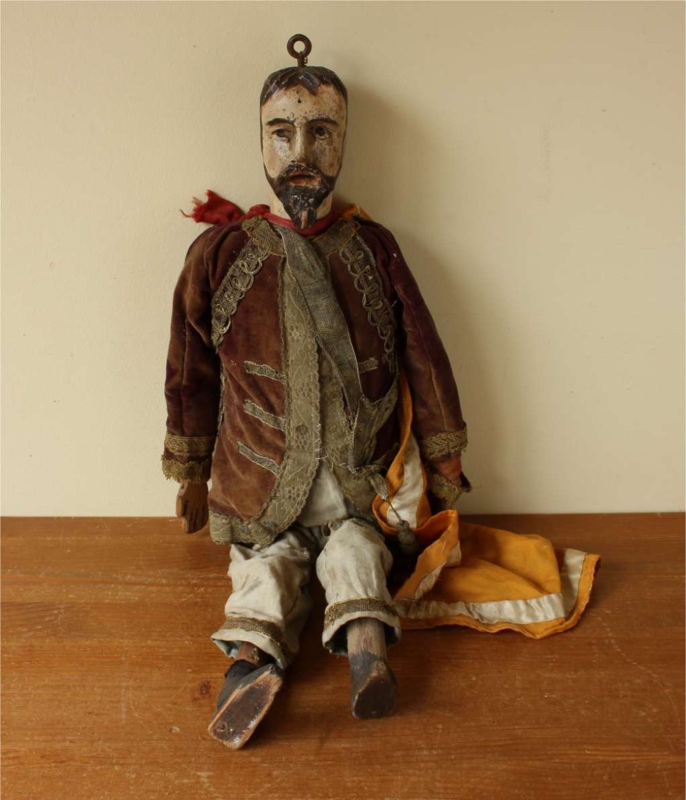 An antique French folk art marionette puppet with a hand-carved bearded wooden head, articulated limbs, and a brown velvet jacket trimmed with braid. View IV