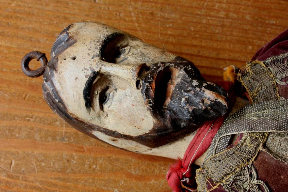 An antique French folk art marionette puppet with a hand-carved bearded wooden head, articulated limbs, and a brown velvet jacket trimmed with braid. View VII